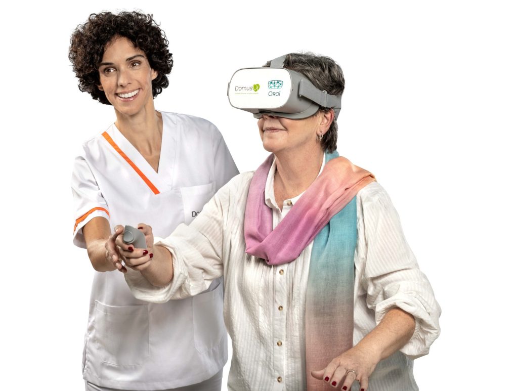 Persona mayor usando gafas de realidad virtual con cuidadora